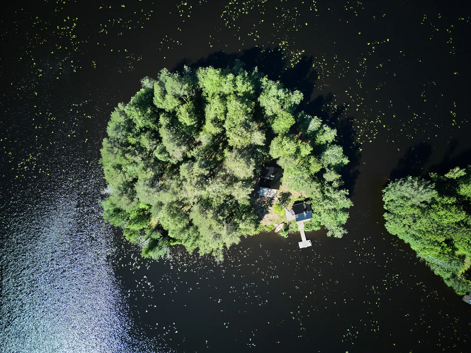 Die Insel senkrecht von oben, umgeben von dunklem Wasser